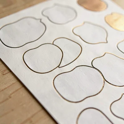 Surface macro of a kiss-cut sheet showing precise outlines around each sticker s