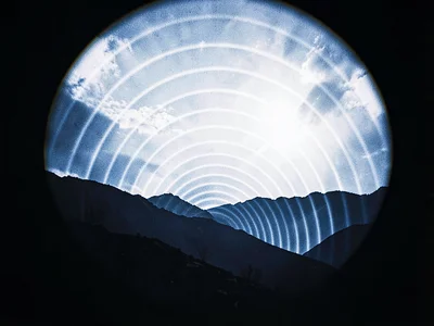 A mountain ridge silhouette with tight arc bands from a high-altitude exposure