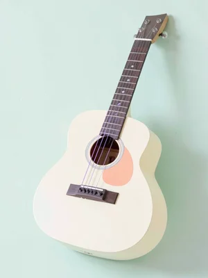 Strummed cream-toned lowpoly acoustic guitar with peach soundhole rim and lavend