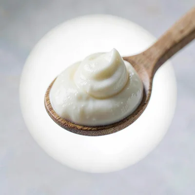 Macro of a single dollop of yogurt on a wooden spoon, lightbox halo