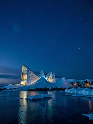 Polar night blue hour in Tromso, Norway, the Arctic Cathedral illuminated agains