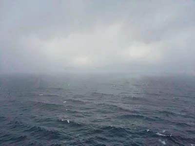 The sea meeting sky in dense fog, horizon line barely visible