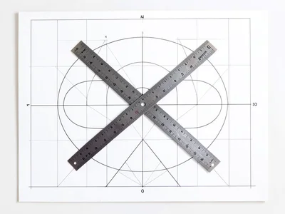 Architect's T-square and set square crossed on white drafting board