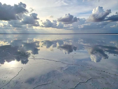 Clouds extending continuously through mirror surface