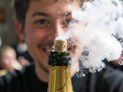 A champagne cork frozen just after leaving the bottle, the gas visible as a froz
