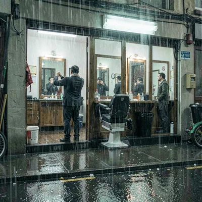 Monsoon season photograph, heavy rain atmosphere, A barbershop open to the stree