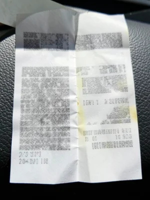 Thermal receipt exposed to sunlight on a dashboard, one half completely blanked,