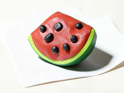 Squat chunky clay watermelon slice in cherry red with chunky black squat seeds a