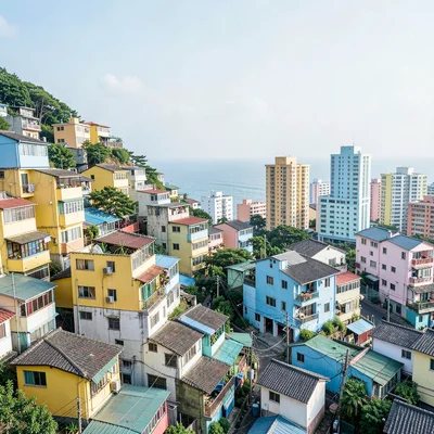 Busan vertical density, hillside village stacking, yellow and blue houses with o
