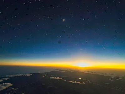 Morning star visible in deep blue above golden horizon glow