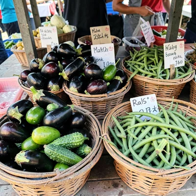 Vegetable stall with eggplants, bitter gourds, okra, green beans piled in basket