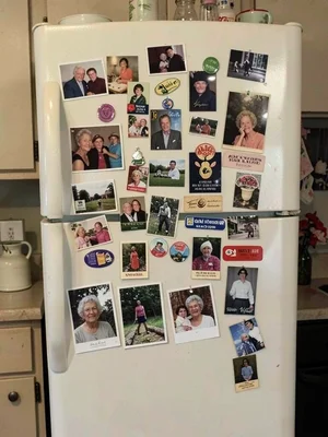 Grandmother's refrigerator door, fifty years of magnets and photos and coupons a