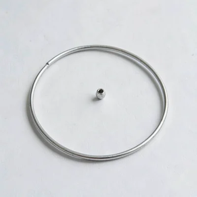 Catalog flat of a circular needle laid in a clean S-curve on a flat surface