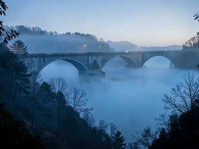 Bridge arches partially visible above and below fog layer