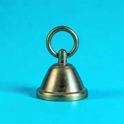 small vintage-style brass desk-bell straight-on against a saturated cyan backdro