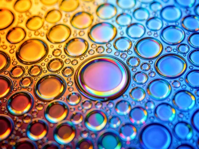 Oil cells lit from beneath with gradient light: warm left to cool right, bubbles