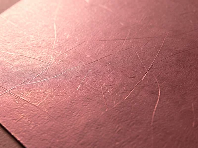 Rose gold foil close up, warm pink metallic surface with micro-scratches creatin