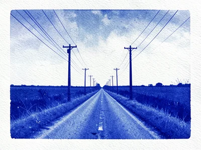 Power lines and utility poles receding down a straight road to the horizon