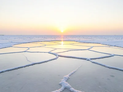 Salt flat at dawn — the first light striking a thin water layer and turning ever