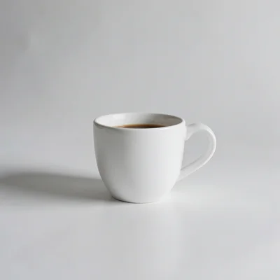 Minimalist photography of a single white coffee cup on a clean matte surface, soft natural window light, subtle shadow, 