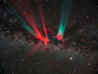 An emission nebula in narrowband false color — hydrogen-alpha pillars in deep re