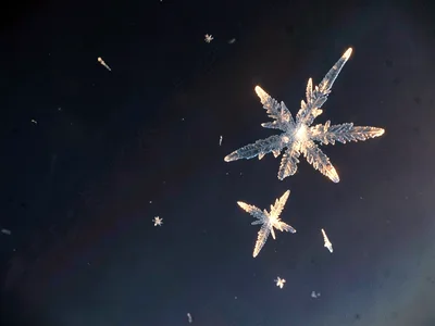 Ice crystals in thin air catching last light against darkening void