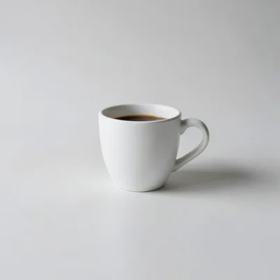 Minimalist photography of a single white coffee cup on a clean matte surface, centered composition, soft natural window 