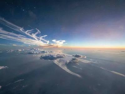 Cirrus clouds catching light in the mesosphere zone of visible color