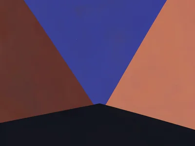 Narrow gap between two copper-red massifs frames a deep lapis sky beyond, hard m