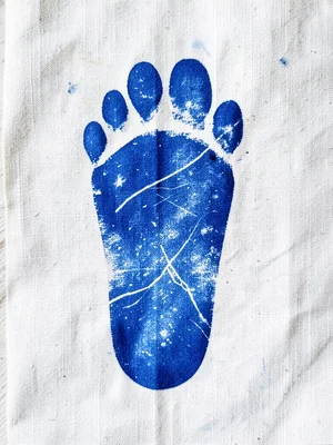 A foot sole pressed onto cyanotype linen — lines of the foot in Prussian blue de