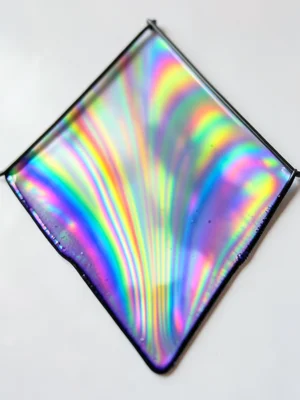 Soap film stretched across a large triangular wire frame, gravity pulling thickn