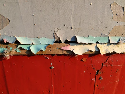 Marine paint on ship hull, anti-fouling red below waterline meeting grey above, 