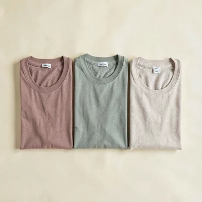 Tomas-blockcolor flatlay of three folded lounge tees in dusty rose, sage, and bo