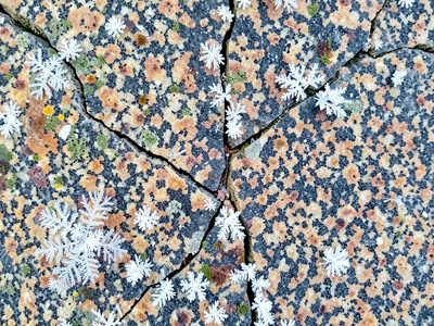 Winter frost in granite cracks white