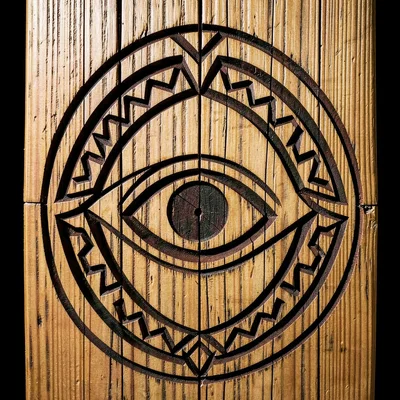 Detail of carved cedar panel — single ovoid eye motif with surrounding U-form la