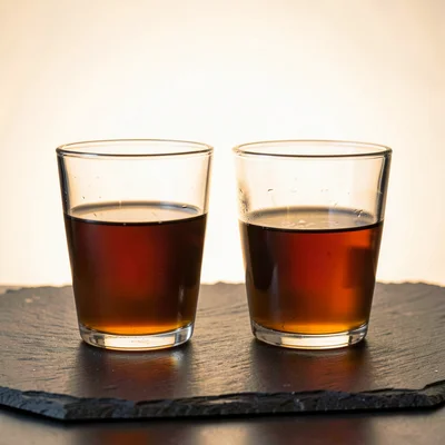 Two glasses on a slate surface with lightbox-soft backlight