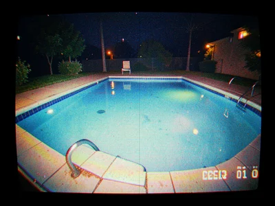 An empty swimming pool at night filmed from a security camera perspective