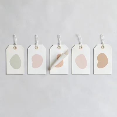 A horizontal row of five abstract gift-tag designs in a clean row with thin gutt