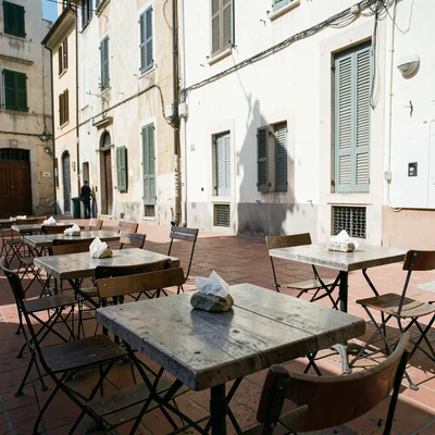 Siesta stillness, afternoon heat weight, Empty outdoor tables with paper napkins