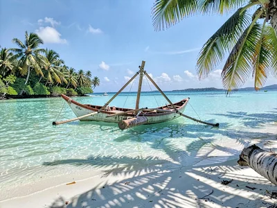 Lagoon turquoise light in Rarotonga, A traditional outrigger canoe resting in st