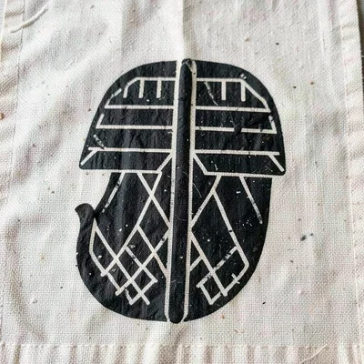Ese Ne Tekrema symbol on cloth — comb and tongue form, crisp dye impression