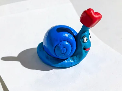 Smiling chunky clay snail mailbox in primary blue with stubby cherry-red flag an