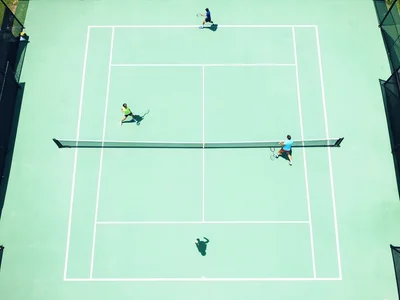 Tennis court from above, mint green surface, white lines, symmetrical, two playe
