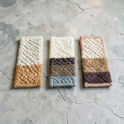 Sculptural lineup of five rug knot samples in graduated densities on chalky conc