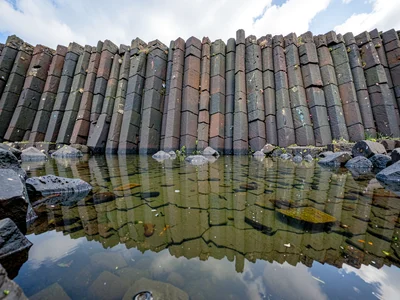 Basalt columns reflected in still tidal pool
