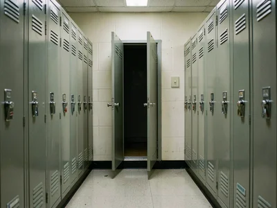 School lockers, every door closed except the exact middle one, gaping open