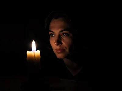 Single candle illuminating face