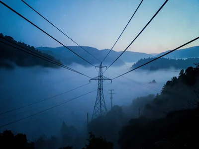 Power lines creating geometric pattern above fog