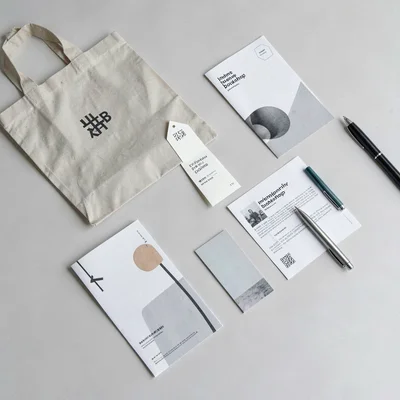 A scattered desk overhead with abstract independent-bookshop collateral — bag, b