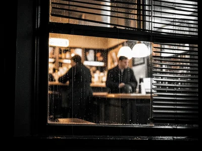 Pub window from outside at night, condensation on glass, warm amber interior blu